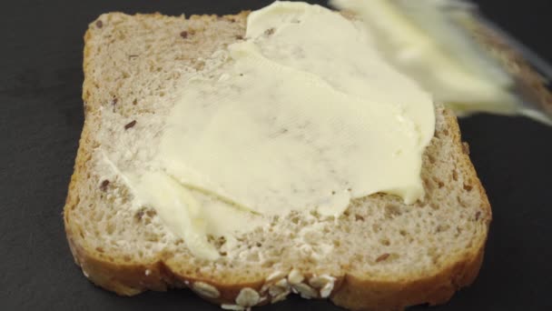 Messer Legt Butter Auf Eine Scheibe Getreidebrot Und Breitet Aus — Stockvideo