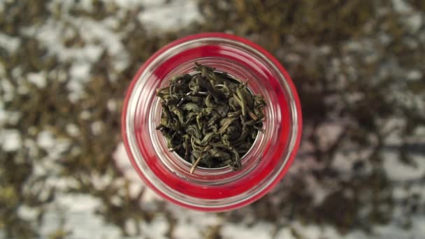 Feuilles de thé vert sec tombent dans la passoire de la théière gros plan — Video