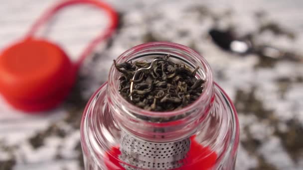 绿茶干枯的卷叶掉进玻璃杯茶壶里 慢动作有选择的重点 中国传统风味饮料 — 图库视频影像