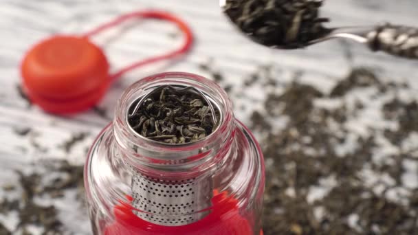 Teaspoon adds dried green tea leaves to the teapot — Stock Video