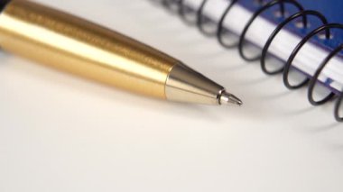 Mavi bir defter ve gri bir ofis masasında altın bir kalem. Planlama kavramı