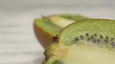 Ahşap bir yüzeye yakın mesafede olgun dilimlenmiş kivi. Makro çekim