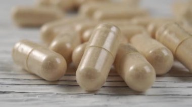 Tahta bir arka planda tıbbi homeopatik kapsüller. Makro çekim