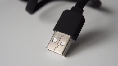 Gri bir yüzeye siyah kabloyla yakın plan Usb tapası. Makro dolly çekimi