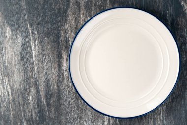 Üstten bakıldığında gri tahta üzerinde mavi kenarlı beyaz bir levha. Kapatın. Boşluğu kopyala