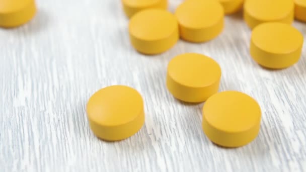 Gelbe Runde Vitamintabletten Gleiten Dahin Und Erscheinen Langsam Auf Einem — Stockvideo