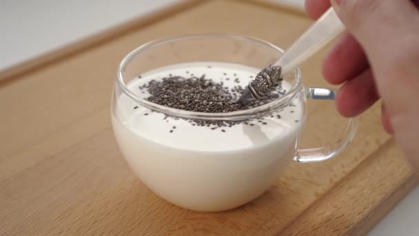 在木板上的杯子里 把咖啡或酸奶和奇亚种子混合在一起 — 图库视频影像