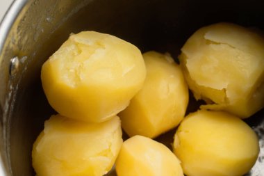 Çelik tencerede haşlanmış patatesleri yakından çek. Pişmiş sebze. 