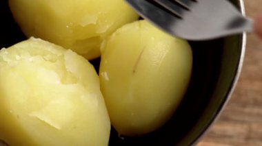 Tahta masadaki seramik kasede çatalla patates püresi hazırlıyorum. Ev yapımı sağlıklı yemekler.