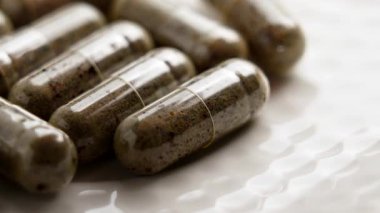 Hasta eli tıbbi bir bitkisel kapsül alır. Makro çekim