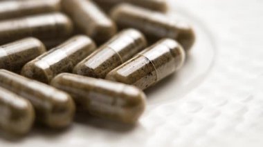 Beyaz seramik üzerine bitkisel ilaç takviyesi. Makro. Döndürme