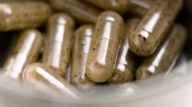 Bitkisel kapsülleri olan dönen metal kaplar. İyileştirici takviyeler