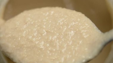 Cam kavanozun üstüne kaşık içinde taze susam ezmesi. Makro