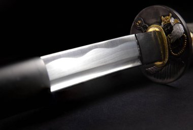 Tsuba'yı (garda) katana Japon kılıç yakın çekim siyah bir zemin üzerine
