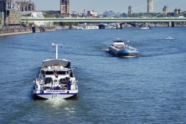 Cologne, Germany August 19 2025: A bulk carrier traveling downstream and a tanker traveling upstream meet on the Rhine near Cologne's old town