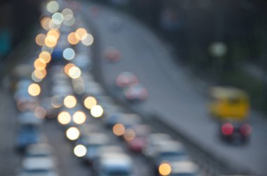 Akşamları kalabalık otoyolda hareket halindeki arabalarla şehir bulanıklaşır.