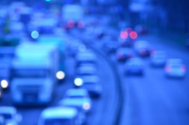 Akşamları kalabalık otoyolda hareket halindeki arabalarla şehir bulanıklaşır.