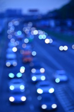 Yoğun otoyolda hareketli arabalarla şehir manzarası bulanık