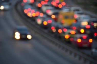 Akşamları kalabalık otoyolda hareket halindeki arabalarla şehir bulanıklaşır.