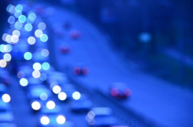 Akşamları kalabalık otoyolda hareket halindeki arabalarla şehir bulanıklaşır.