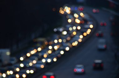 Akşamları kalabalık otoyolda hareket halindeki arabalarla şehir bulanıklaşır.