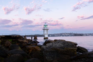 Güzel pembe ve mor gökyüzü ile günbatımı sırasında Sydney deniz feneri
