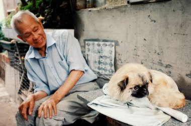 Beijing / China - 24 Haziran 2011: iki adam bir geleneksel Çince şehir hutong evlerinde dışında bir köpekle oynayan