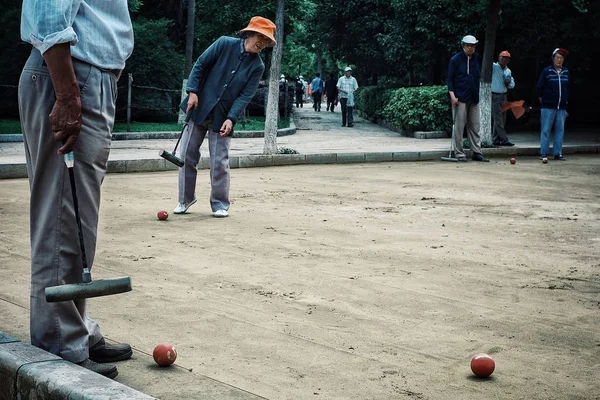 Xi'an / Çin - 24 Haziran 2011: yaşlı adam kroket arkadaş grubu bir parkta oynarken