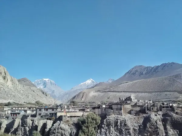 Kagbeni / Nepal - 22 Ekim 2016: yüksek kayalıklarla ve vadi ve biraz kar Kali Gandaki Nehri gorge köyde arka plan dağlarda şapkalı