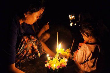 Si Phan Don / Laos - 06 Temmuz 2011: theravada Budist hacı kadın onun sevimli çocukla bir dini kutsal kutlamaları sırasında kadar bir mum ışığı