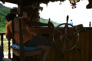 Luang Prabang / Laos - 06 Temmuz 2011: mekong Nehri sığ parçalar arasında direksiyon motorlu tekne Dümenci