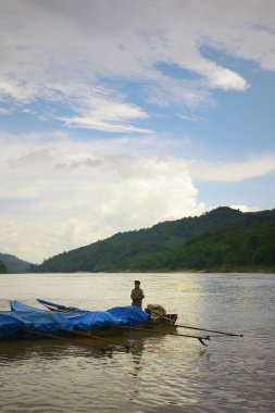 Luang Prabang / Laos - 06 Temmuz 2011: yerel mekong Nehri balıkçı onun motor Kano günbatımında rıhtım