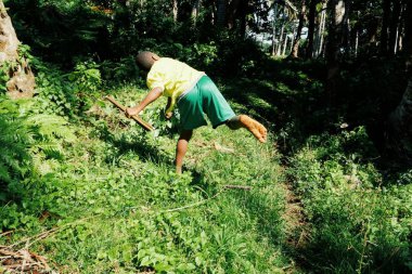 Olal Köyü, Ambrym Island / Vanuatu Cumhuriyeti - 9 Temmuz 2016: okul onun Köyü avcılık küçük kuşlar için yanında bir üniformalı öğrenci çocukla bir bumerang tropikal yağmur ormanları orman