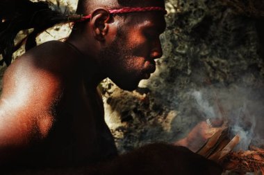 Walarano Köyü, Malekula Island / Vanuatu Cumhuriyeti - 9 Temmuz 2016: bir mağarada geleneksel sürtünme matkap yolda ışık için ateşe üfleme yerel kabile adam