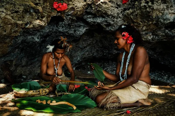 Walarano Köyü, Malekula Island / Vanuatu Cumhuriyeti - 9 Temmuz 2016: geleneksel laplap yemek yemek bambu ve muz yaprak içinde tropikal deniz kıyısında iki kabile kadın
