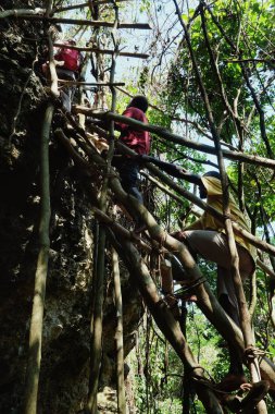 Lolits Köyü, Espiritu Santo Adası / Vanuatu Cumhuriyeti - 10 Ağustos 2016: büyük taş taş cliff üzerinde eğreti bambu ve ağaç gövde Merdiven tırmanma köylüler
