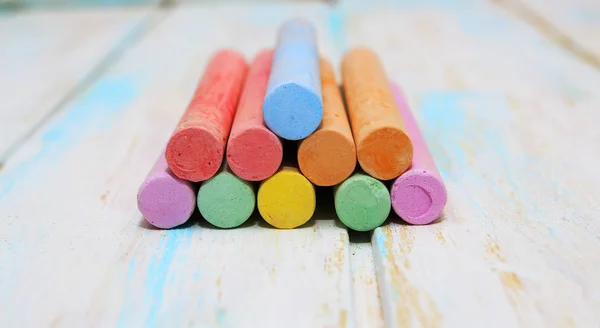 Gekleurd krijt voor het tekenen op een witte houten achtergrond — Stockfoto