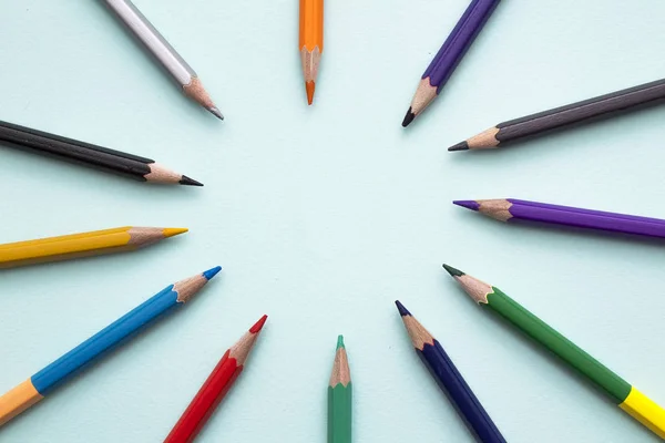 Crayons de couleur dans organiser en couleurs de roue de couleur sur fond bleu. Vie top. Une place libre pour le texte . — Photo