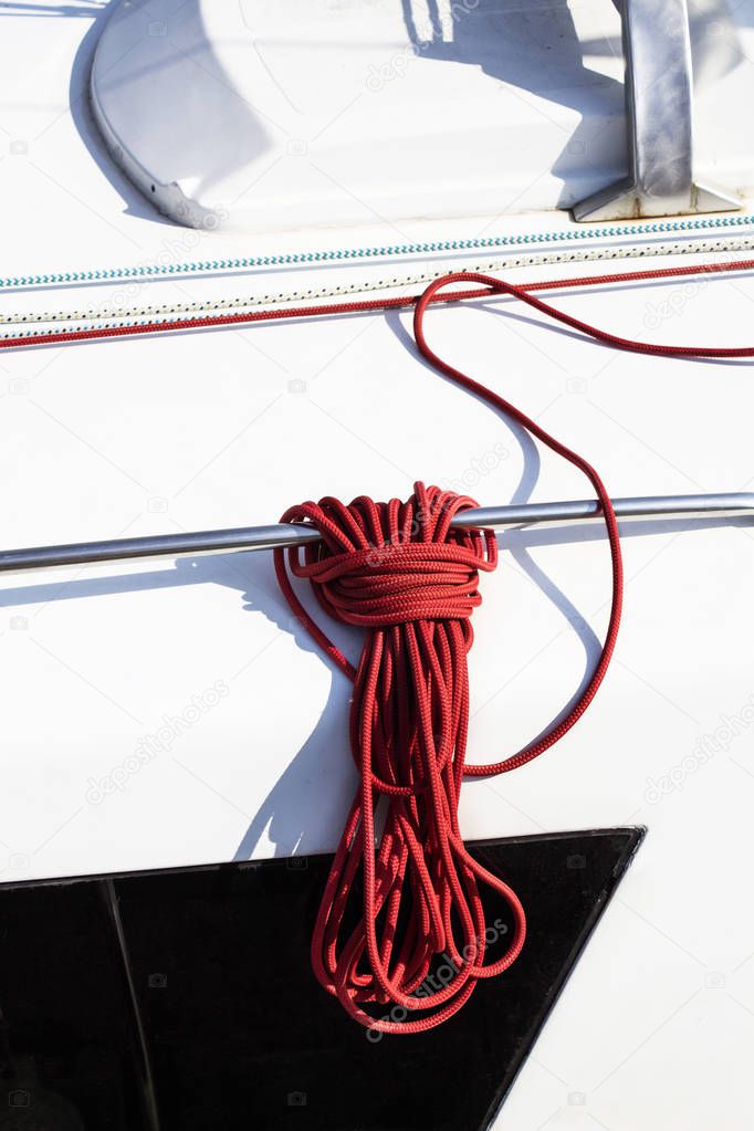 Marine red rope on a white deck on a yacht