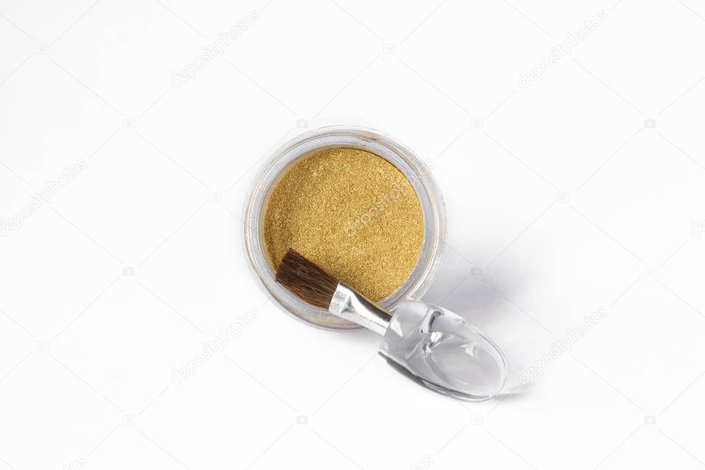 Gold eye shadows and eye brush  isolated on white background. Concept of makeup and beauty.
