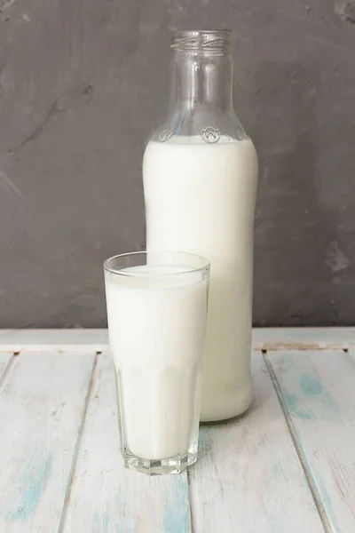 Fresh milk in a glass and a bottle on a wooden background. Dairy products as a source of calcium. Healthy eating