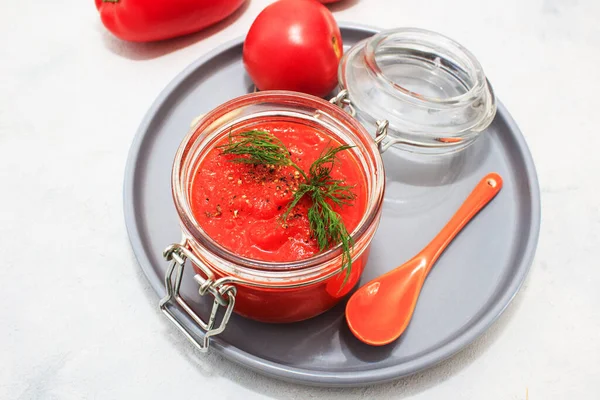 Ajvar, peppar mousse i en burk och på grå platta och grå bakgrund — Stockfoto