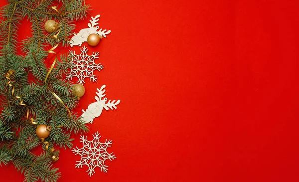 Noel ve Yeni Yıl kompozisyonu, altın parıltılı top ve kırmızı arka planda şerit. Yakın çekim, kopyalama alanı. Noel ağacı ve oyuncaklarının dalı