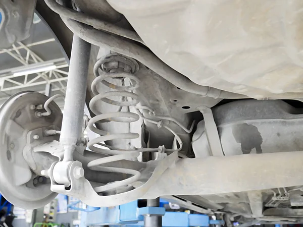 Araba servis merkezinde onarım ve bakım için otomobilin amortisörlerin geri kontrolü.