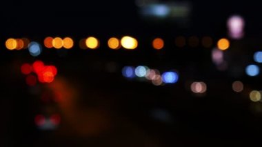 Şehrin sokaklarında çalışan arabaların ışıklarından bokeh daireler hareket. Şehir bulanıklığı arka plan. Gece trafiği.