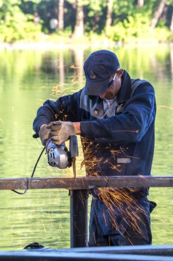 Balashikha, Moscow area, Rusya Federasyonu - 16 Haziran 2018: Şehir Park Pekhorka nehrinde set of inşaat metal tasarımları bölümlerini işçi keser