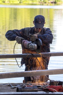 Balashikha, Moscow area, Rusya Federasyonu - 16 Haziran 2018: Şehir Park Pekhorka nehrinde set of inşaat metal tasarımları bölümlerini işçi keser