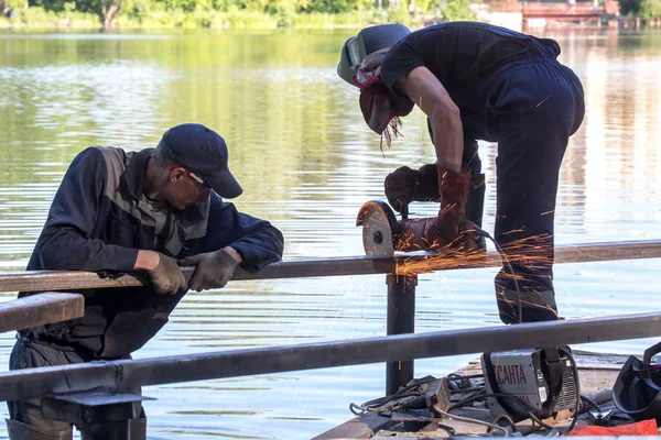 Balashikha, Moscow area, Rusya Federasyonu - 16 Haziran 2018: Şehir Park Pekhorka nehrinde set of inşaat metal tasarımları bölümlerini işçi keser