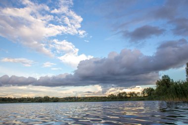 Bir göl ile akşam bulutlar üzerinde yaz günbatımı