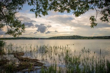 Bir göl ile akşam bulutlar üzerinde yaz günbatımı
